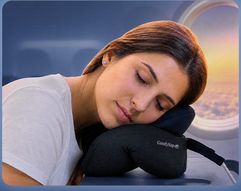 Traveler resting forward on the pillow laid flat on a tray table
